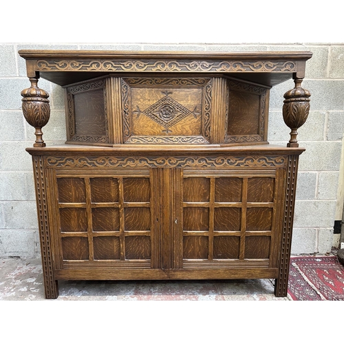 53 - A mid 20th century Jacobean style carved oak court cupboard - approx. 143cm high x 152cm wide x 52cm... 