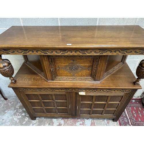 53 - A mid 20th century Jacobean style carved oak court cupboard - approx. 143cm high x 152cm wide x 52cm... 