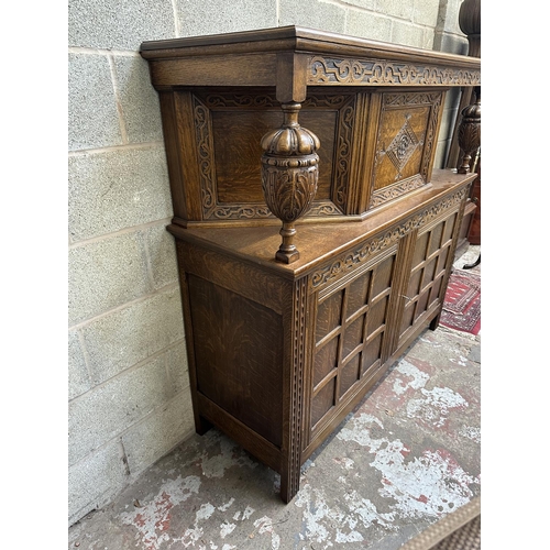 53 - A mid 20th century Jacobean style carved oak court cupboard - approx. 143cm high x 152cm wide x 52cm... 