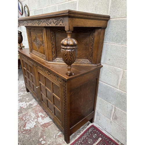 53 - A mid 20th century Jacobean style carved oak court cupboard - approx. 143cm high x 152cm wide x 52cm... 