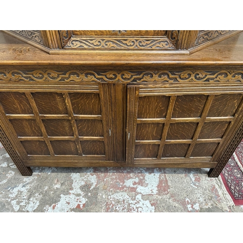 53 - A mid 20th century Jacobean style carved oak court cupboard - approx. 143cm high x 152cm wide x 52cm... 