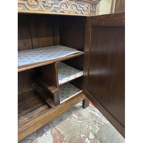 53 - A mid 20th century Jacobean style carved oak court cupboard - approx. 143cm high x 152cm wide x 52cm... 