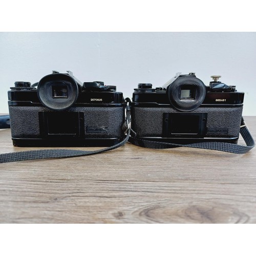 949 - Two Canon A-1 35mm SLR cameras, one fitted with Makinon MC 1:3.5-4.5 28-80mm auto zoom lens and one ... 