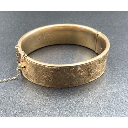 2056 - A hallmarked Birmingham 9ct gold foliate etched bangle with internal presentation inscription, dated...