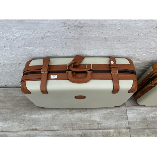 1059 - Two Italian Bojola Original Saddler cream plastic and tan leather suitcases - largest approx. 52cm h... 