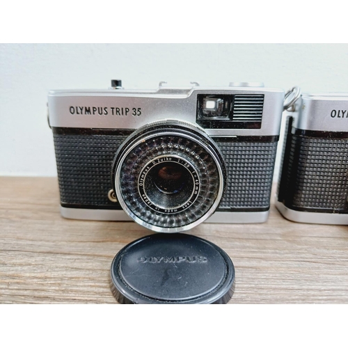 24 - Two Olympus Trip 35 fully-automatic compact 35mm cameras, one with lens cap