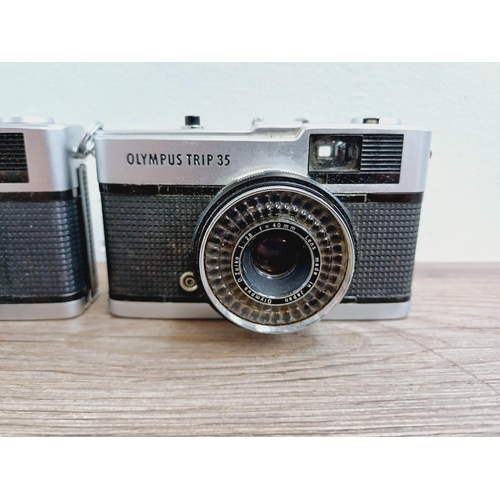 24 - Two Olympus Trip 35 fully-automatic compact 35mm cameras, one with lens cap