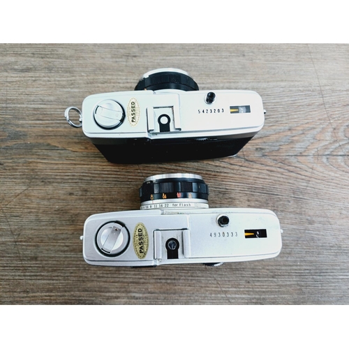 24 - Two Olympus Trip 35 fully-automatic compact 35mm cameras, one with lens cap