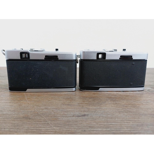 24 - Two Olympus Trip 35 fully-automatic compact 35mm cameras, one with lens cap