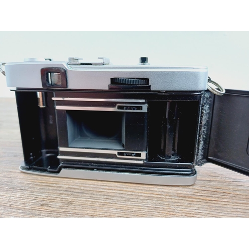 24 - Two Olympus Trip 35 fully-automatic compact 35mm cameras, one with lens cap