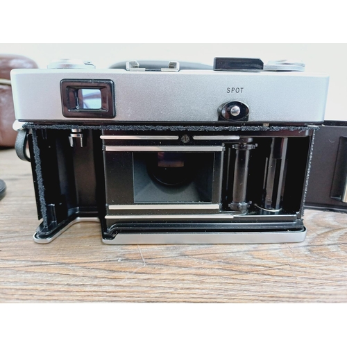 21 - Two cased 35mm cameras, one Olympus 35 SP spot and centre-weighted metering rangefinder fitted with ... 