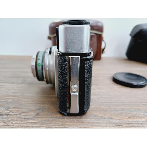 21 - Two cased 35mm cameras, one Olympus 35 SP spot and centre-weighted metering rangefinder fitted with ... 