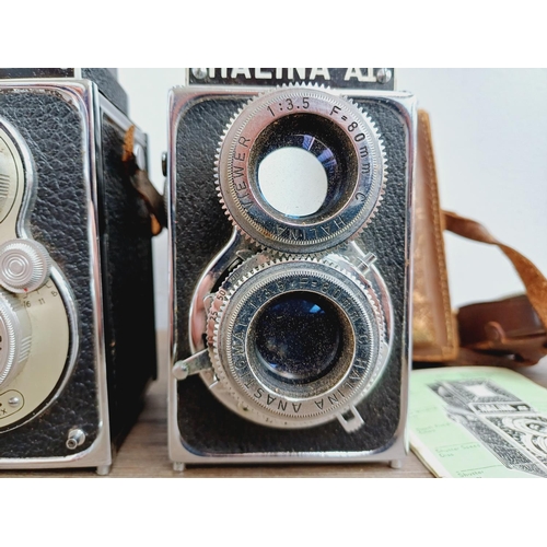 48 - Two cased Haking Halina cameras for 6x6 images on 120 film, one A1 TLR fitted with 1:3.5 80mm lenses... 