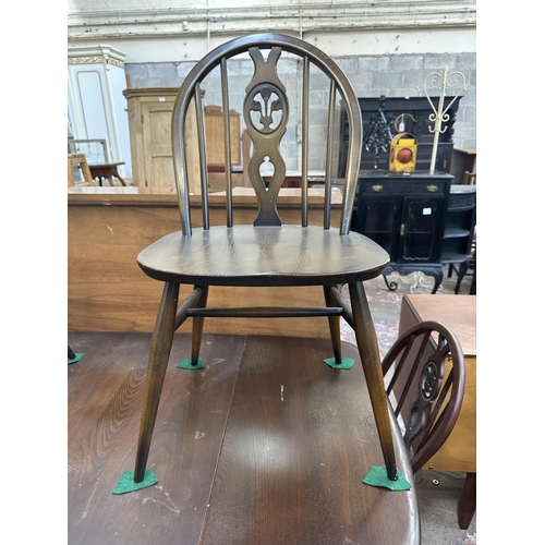 1149 - A mid 20th century Ercol Old Colonial elm and beech dining table and six Ercol Fleur-De-Lys dining c... 