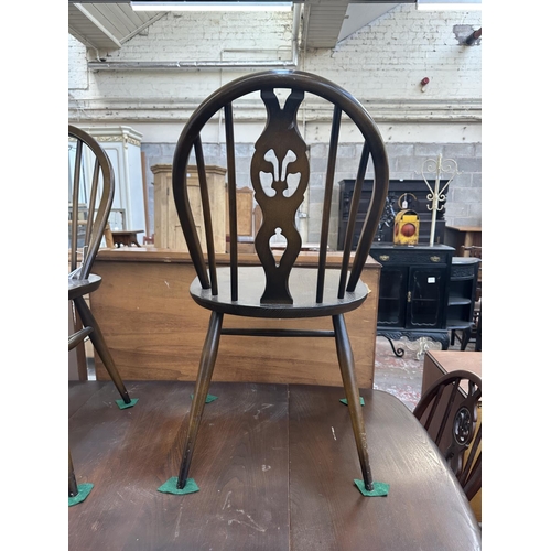 1149 - A mid 20th century Ercol Old Colonial elm and beech dining table and six Ercol Fleur-De-Lys dining c... 