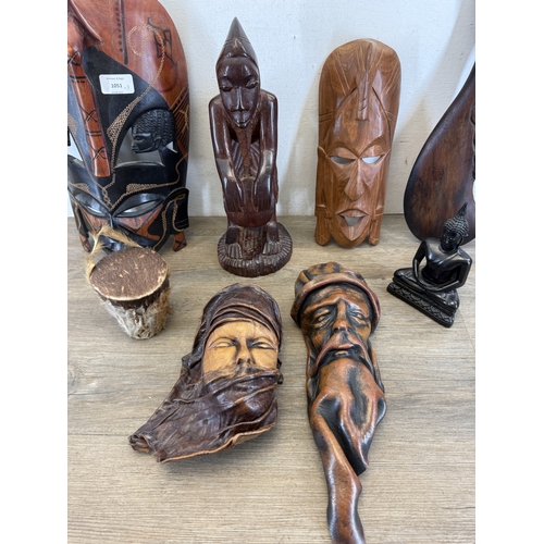 1051 - Eight ethnographical items to include two leather wall masks, hand carved hardwood wall mask made in... 