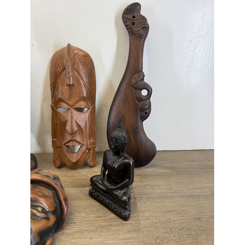 1051 - Eight ethnographical items to include two leather wall masks, hand carved hardwood wall mask made in... 