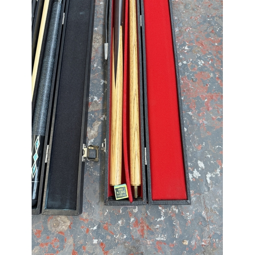 Three cased pool cues to include Waslin, Kruger etc.