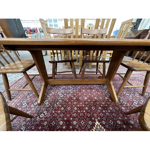 42 - A 1970s Reynolds of Ludlow walnut dining table and eight Ercol style beech spindle back dining chair... 