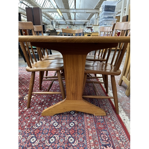 42 - A 1970s Reynolds of Ludlow walnut dining table and eight Ercol style beech spindle back dining chair... 
