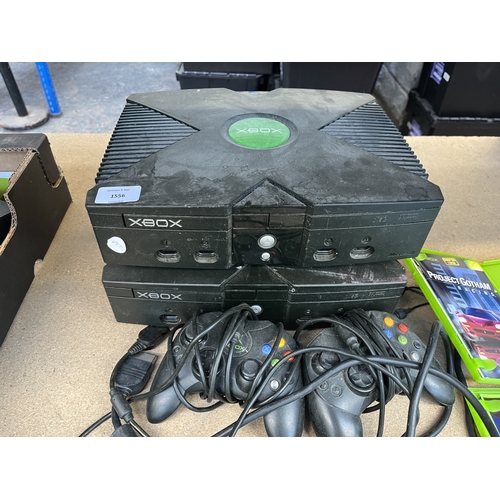 Two Xbox consoles with two controllers and four game discs