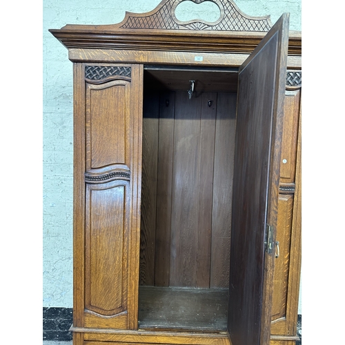 1002 - An early 20th century carved oak mirror door wardrobe - approx. 213cm high x 134cm wide x 52cm deep
