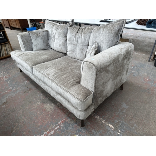 1016 - A modern silver fabric upholstered three seater sofa on hardwood supports - approx. 78cm high x 200c... 
