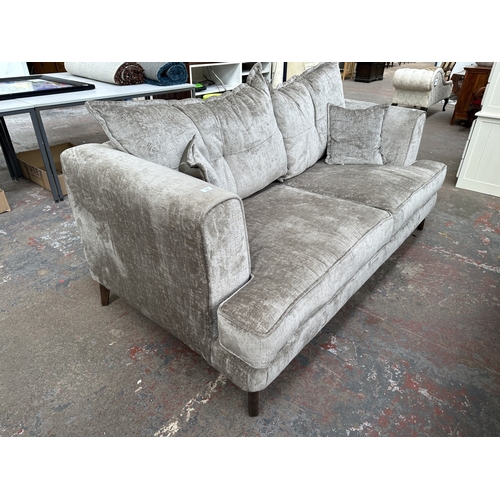 1016 - A modern silver fabric upholstered three seater sofa on hardwood supports - approx. 78cm high x 200c... 