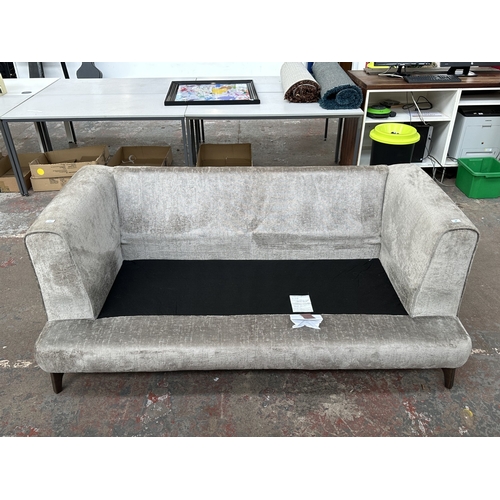 1016 - A modern silver fabric upholstered three seater sofa on hardwood supports - approx. 78cm high x 200c... 