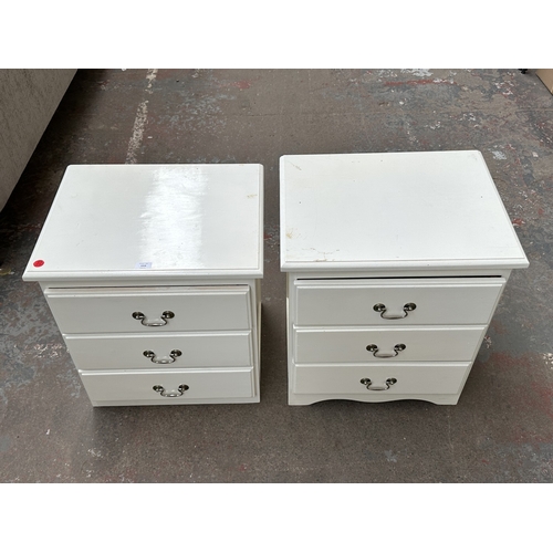 1028 - Two white painted bedside chests of drawers - approx. 62cm high x 57cm wide x 45cm deep