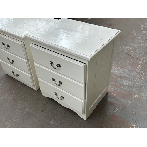 1028 - Two white painted bedside chests of drawers - approx. 62cm high x 57cm wide x 45cm deep
