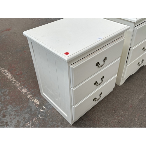 1028 - Two white painted bedside chests of drawers - approx. 62cm high x 57cm wide x 45cm deep