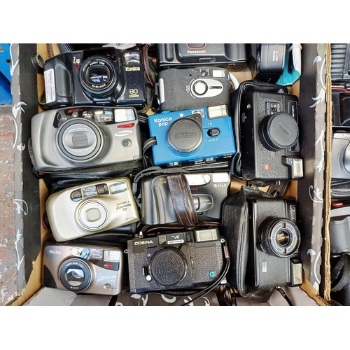 Two boxes containing cameras to include Konica, Yashica, Fuji, Halina etc.