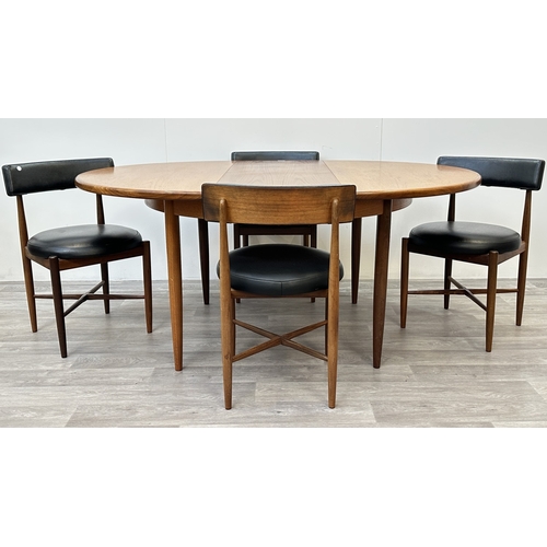 A mid 20th century G Plan Fresco teak circular extending dining table and four black vinyl chairs - approx. 73cm high x 122cm wide x 167cm long