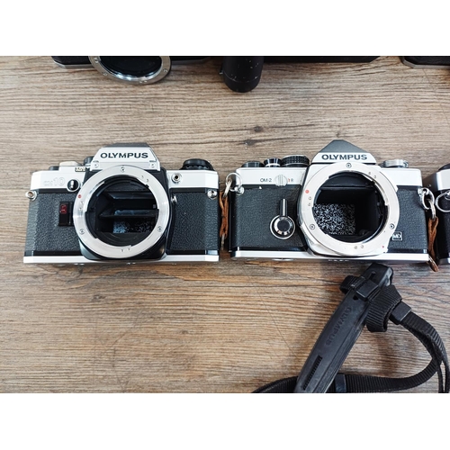 101 - Nine Olympus 35mm SLR camera bodies, five OM10, one OM-2 (A/F), one OM30 and two OM20