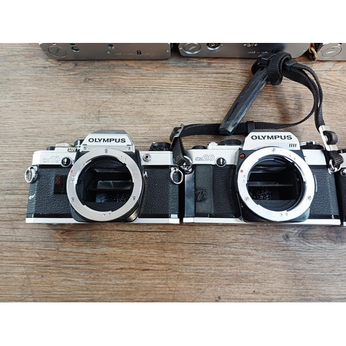 101 - Nine Olympus 35mm SLR camera bodies, five OM10, one OM-2 (A/F), one OM30 and two OM20