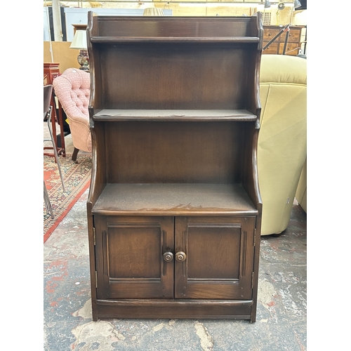 17 - An Ercol Model 476 elm waterfall bookcase - approx. 111cm high x 61cm wide x 34cm deep