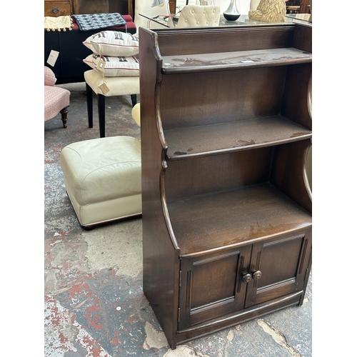 17 - An Ercol Model 476 elm waterfall bookcase - approx. 111cm high x 61cm wide x 34cm deep