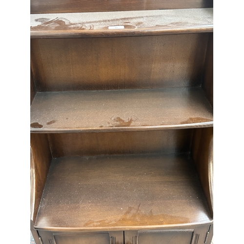 17 - An Ercol Model 476 elm waterfall bookcase - approx. 111cm high x 61cm wide x 34cm deep