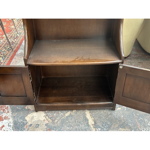 17 - An Ercol Model 476 elm waterfall bookcase - approx. 111cm high x 61cm wide x 34cm deep