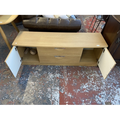 23 - A modern oak effect TV stand - approx. 51cm high x 145cm wide x 42cm deep