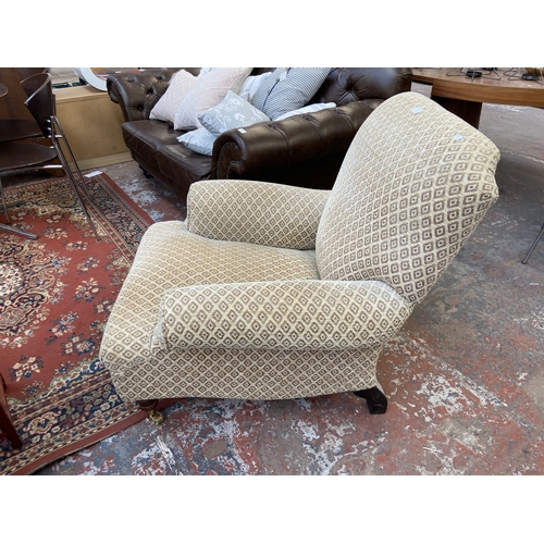 30 - A Victorian style beige fabric upholstered armchair on beech supports and brass castors - approx. 87... 