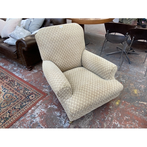 30 - A Victorian style beige fabric upholstered armchair on beech supports and brass castors - approx. 87... 