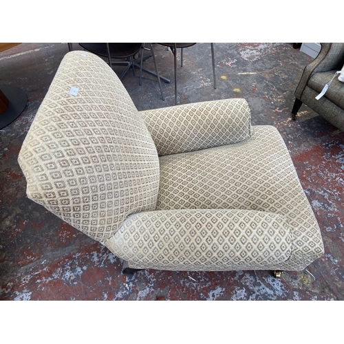 30 - A Victorian style beige fabric upholstered armchair on beech supports and brass castors - approx. 87... 