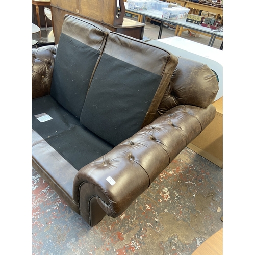 32 - A brown leather Chesterfield two seater sofa - approx. 92cm high x 175cm wide x 105cm deep