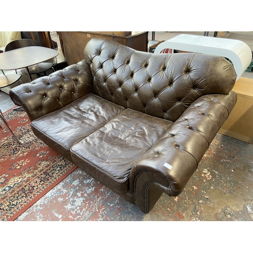 32 - A brown leather Chesterfield two seater sofa - approx. 92cm high x 175cm wide x 105cm deep