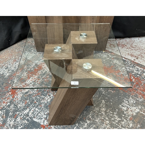 49 - Two Harveys walnut effect and glass top Piston occasional tables, one console - approx. 76cm high x ... 