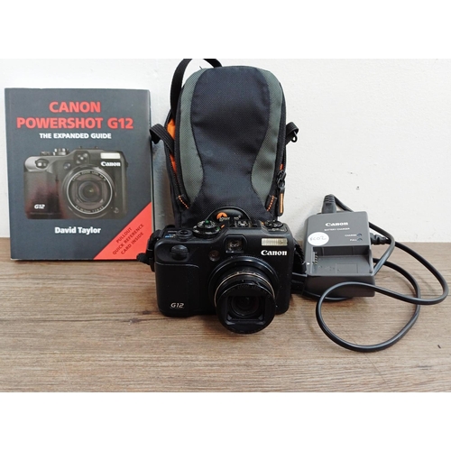 A cased Canon PowerShot G12 10mp CCD sensor compact digital camera with charger and 'Expanded Guide' book