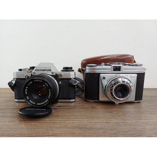 191 - Two 35mm cameras, one Olympus OM10 35mm SLR fitted with Zuiko MC Auto-S 1:1.8 50mm lens and one case... 