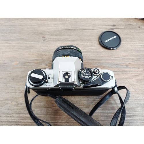 191 - Two 35mm cameras, one Olympus OM10 35mm SLR fitted with Zuiko MC Auto-S 1:1.8 50mm lens and one case... 